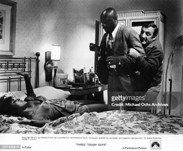 Lino Ventura restrains Isaac Hayes from harming Paula Kelly in a scene from the Paramount Pictures movie "Three Tough Guys", circa 1974.