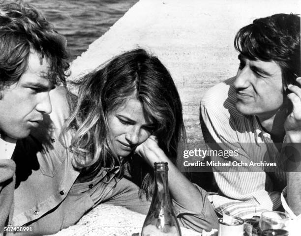 Robie Porter, Charlotte Rampling and Sam Waterston picnic by a sea wall in a scene from the movie "Three" , circa 1967.