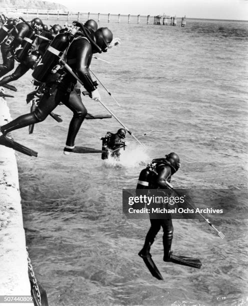 Scuba divers leap into the water in a scene from the movie "Thunderball", circa 1965.