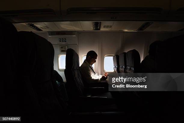Passenger checks a mobile device on an Alas Uruguay jet shortly after takeoff on the inaugural flight to Buenos Aires from Montevideo Carrasco...