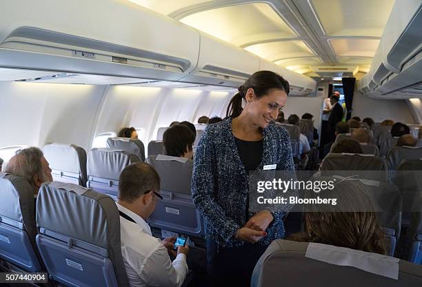 Flight attendant checks on passengers before takeoff on the Alas Uruguay inaugural flight to Buenos Aires at Montevideo Carrasco International...