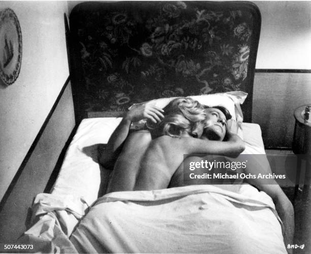 Michel Duchaussoy and Caroline Cellier lay in bed in a scene from the movie "This Man Must Die" , circa 1969.