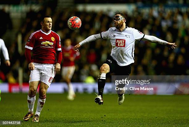 Richard Keogh of Derby County gains possession as Wayne Rooney of Manchester United looks on during the Emirates FA Cup fourth round match between...