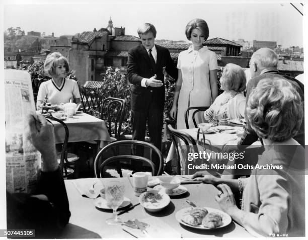 Tammy Grimes looks on as David McCallum introduces his girlfriend Sylva Koscina in a scene from the MGM movie "Three Bites of the Apple", circa 1967.