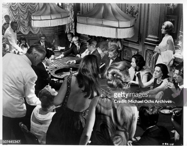 Sylva Koscina observes David McCallum winning streak at a casino in a scene from the MGM movie "Three Bites of the Apple", circa 1967.