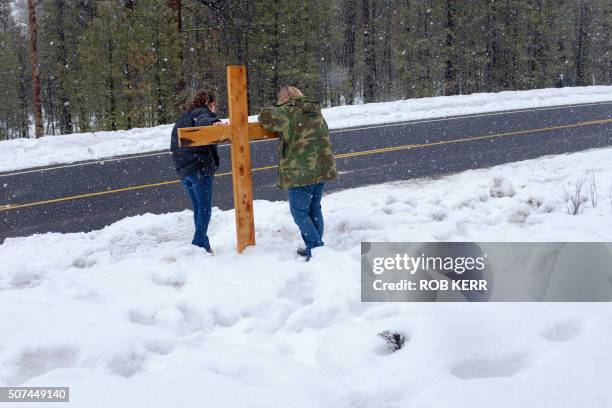 Mandi Jacobs and Jenna Lynn react at a wooden cross on Highway 395 near Burns, Oregon on January 29 at the location where Robert "LaVoy" Finicum was...