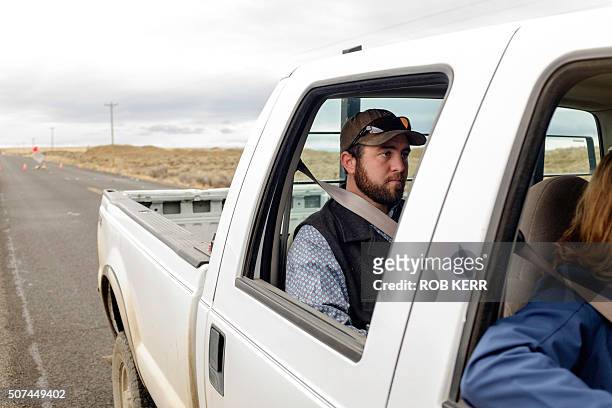 Rancher Tucker Dunbar sits in the cab of his family ranch truck at a checkpoint near the Malheur Wildlife Refuge near Burns, Oregon on January 29,...