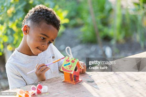 little boy painting bird house - summer camp kids stock pictures, royalty-free photos & images