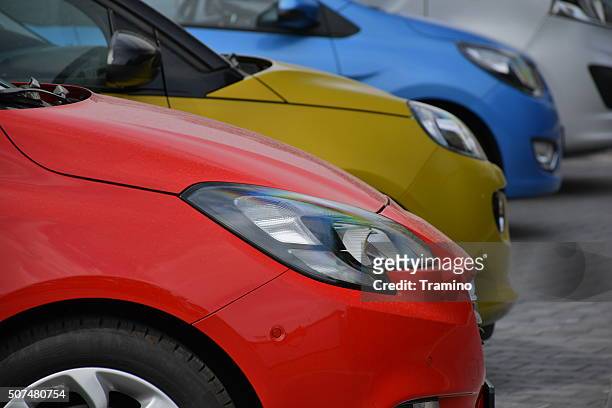 colorato automobili parcheggiate sulla distributore di parcheggio - opel corsa foto e immagini stock