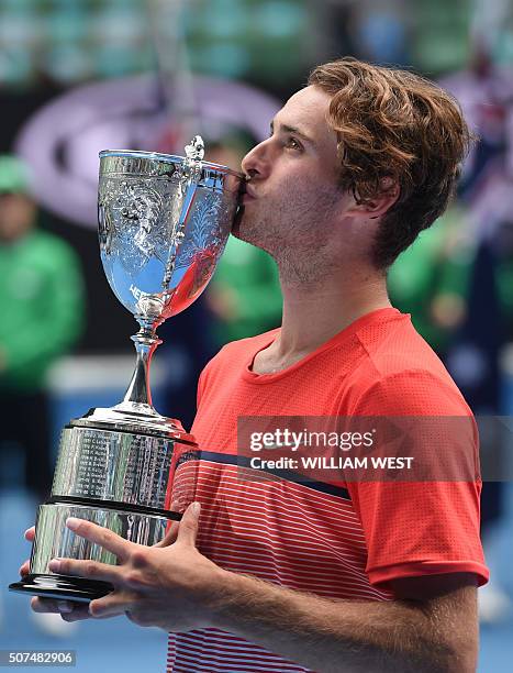 Australia's Oliver Anderson kisses the trophy after victory in his boys singles final match against Uzbekistan's Jurabeck Karimov on day thirteen of...