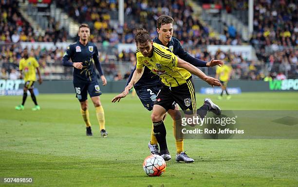 Michael McGlinchey of the Wellington Phoenix controls the ball despite the attention of Jacob Poscoliero of the Central Coast Mariners during the...