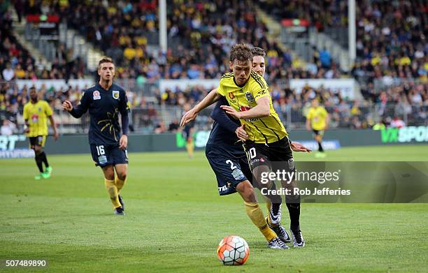 Michael McGlinchey of the Wellington Phoenix controls the ball despite the attention of Storm Roux of the Central Coast Mariners during the round 17...