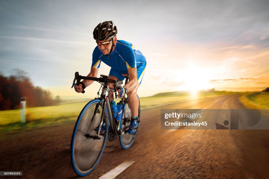 Bicycle Rider pedaling on a Country Road at Sunset