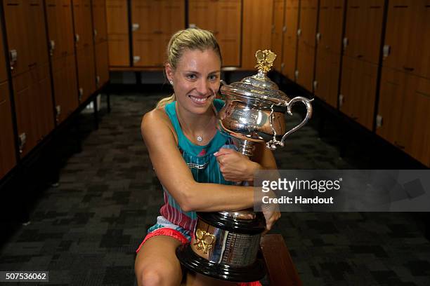 In this handout photo provided by Tennis Australia, Angelique Kerber of Germany poses with the Daphne Akhurst Trophy in the players change rooms...