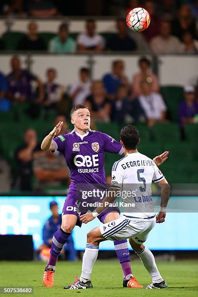 Shane Lowry of the Glory heads the ball against Daniel Georgievski of the Victory during the round 17 A-League match between Perth Glory and...
