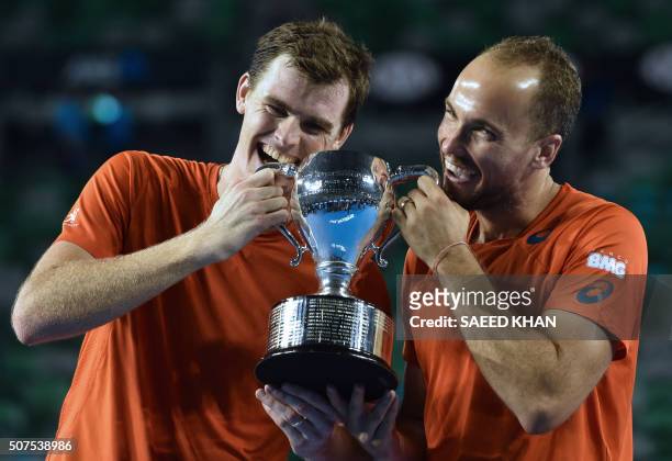 Britain's Jamie Murray and Brazil's Bruno Soares pose with the trophy as they celebrate after victory in their men's doubles final match against...
