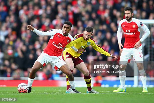 Alex Iwobi of Arsenal controls the ball under pressure of David Jones of Burnley during the Emirates FA Cup Fourth Round match between Arsenal and...