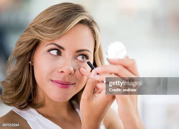 mujer aplicando delineador de ojos - conceptos de maquillaje - eye liner fotografías e imágenes de stock