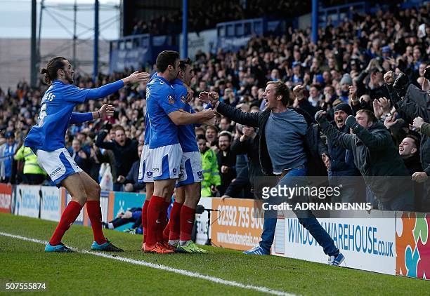 Portsmouth fan jumps on to the pitch as Portsmouth's English midfielder Gary Roberts celebrates scoring his team's first goal during the English FA...
