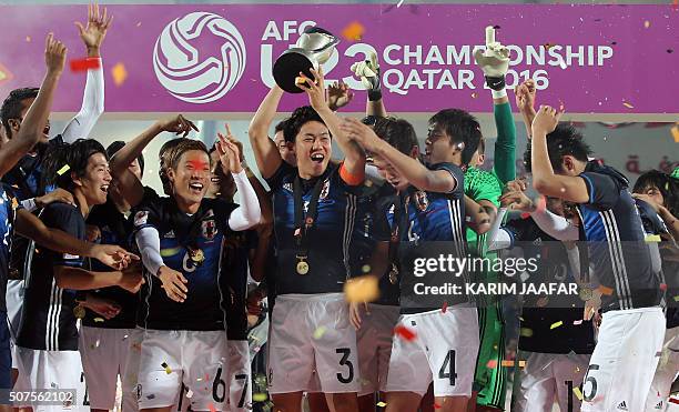 Japan's players celebrate with the trophy following the AFC U23 Championship final football match between Japan and South Korea at Abdullah Bin...