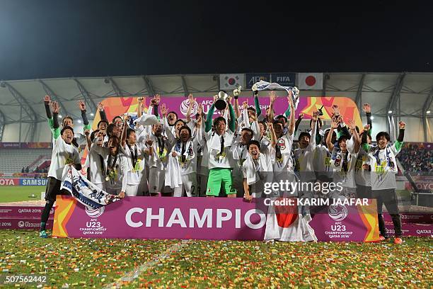 Japan's players celebrate with the trophy following the AFC U23 Championship final football match between Japan and South Korea at Abdullah Bin...