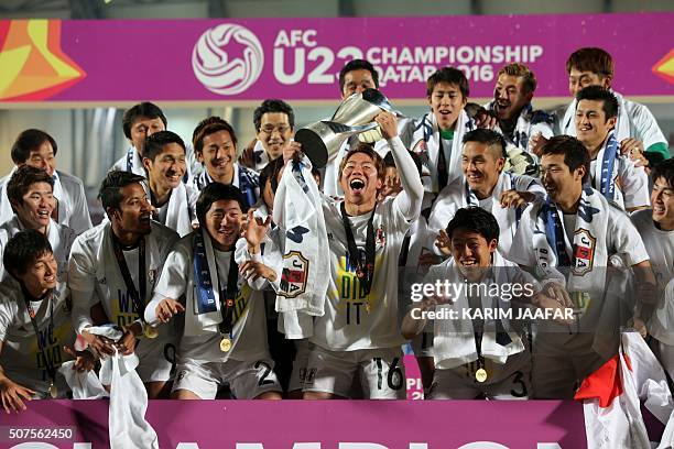 Japan's players celebrate with the trophy following the AFC U23 Championship final football match between Japan and South Korea at Abdullah Bin...