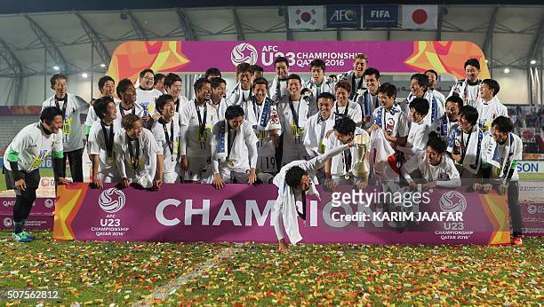 Japan's players celebrate with the trophy following the AFC U23 Championship final football match between Japan and South Korea at Abdullah Bin...