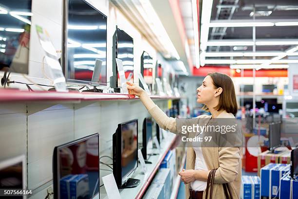 woman buys the tv - consumerism stock pictures, royalty-free photos & images