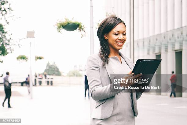 portrait of successful businesswoman using tablet in urban landscape - financial district stock pictures, royalty-free photos & images