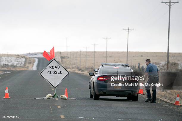 An Oregon State Trooper moves a cone at a road block along the Malheur National Wildlife Refuge January 30, 2016 in Burns, Oregon. Eight protestors...