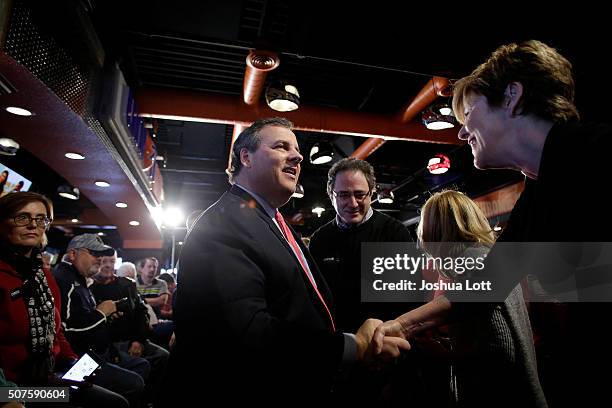 New Jersey Governor and Republican presidential candidate Chris Christie greets people as he arrives at the Chrome Horse Saloon & Slop House during a...