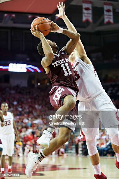 Anthony Collins of the Texas A&M Aggies goes up for a shot against Dusty Hannahs of the Arkansas Razorbacks at Bud Walton Arena on January 27, 2016...