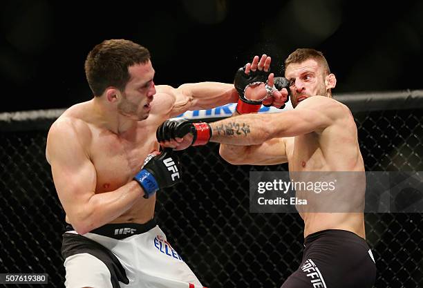 Jake Ellenberger of the United States and Tarec Saffiedine of Belgium exchange punches in their welterweight bout during the UFC Fight Night event at...