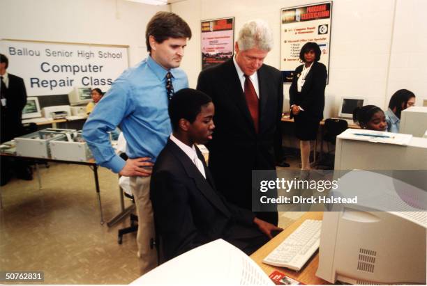 Steve Case & Pres. Bill Clinton watching student at work in computer repair class at Ballou Senior High School.