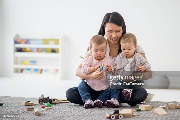 professeur de garde d'enfants sœurs jouant avec lits jumeaux. - fat twins photos et images de collection