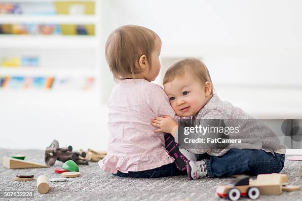 zwei schwestern umarmen in der kinder. - fat twins stock-fotos und bilder