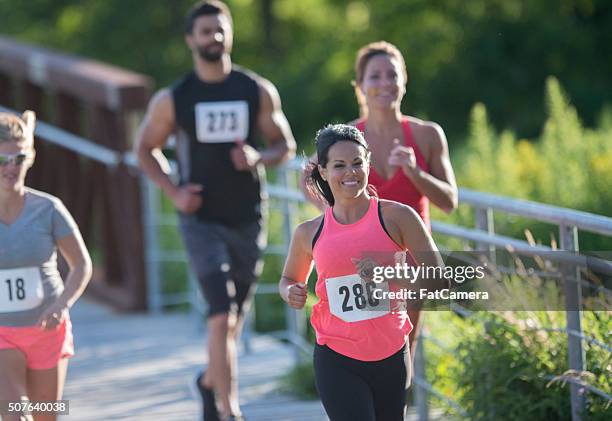 a group of competetive runners racing. - baby bib stock pictures, royalty-free photos & images