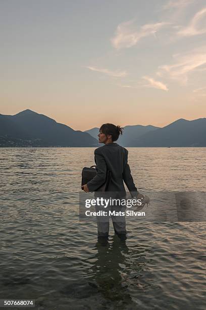 business woman standing in the water - female looking away from camera serious thinking outside natural stock pictures, royalty-free photos & images