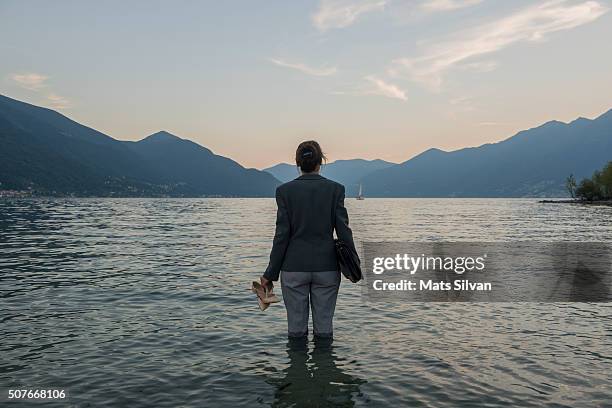 business woman standing in the water - female looking away from camera serious thinking outside natural stock pictures, royalty-free photos & images