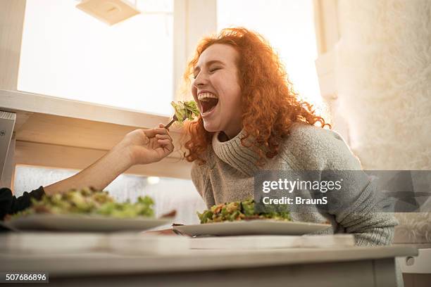 young cheerful woman being fed by unrecognizable man. - mouth open eating stock pictures, royalty-free photos & images