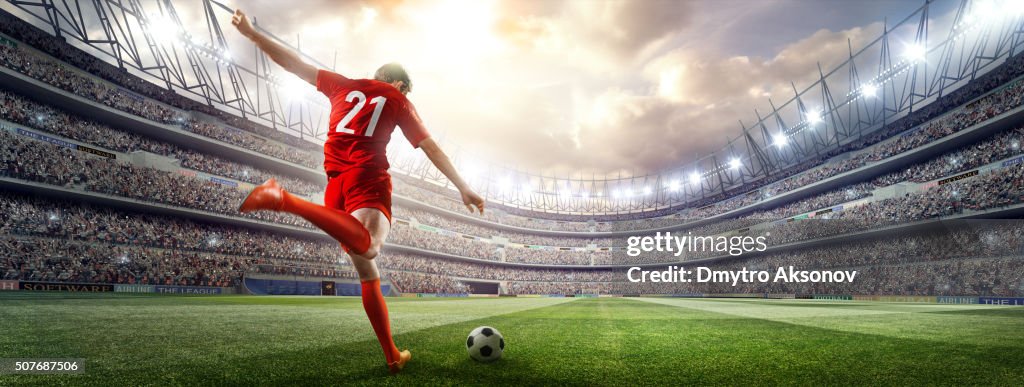 Soccer player kicking ball in stadium