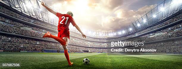 soccer player kicking ball in stadium - football stock pictures, royalty-free photos & images
