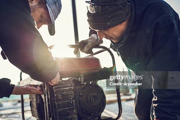 manual workers repairing power generator. - portability stock pictures, royalty-free photos & images