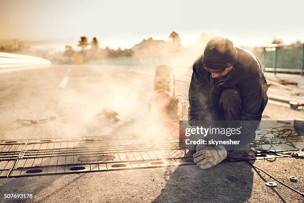 manual worker working on road reparation. - dirty construction worker stock pictures, royalty-free photos & images