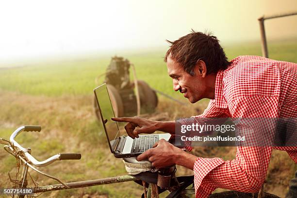 farmer using laptop in the field - rural internet stock pictures, royalty-free photos & images