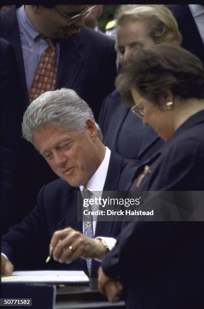 Pres. Bill Clinton poised w. Pen during White House Nato expansion signing ceremony.