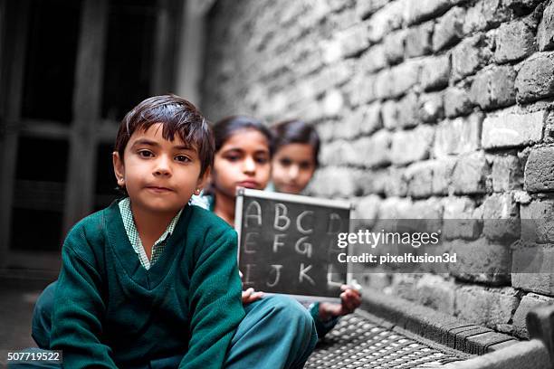 kleine schule schüler porträt zu hause halten tafel - indian school children stock-fotos und bilder