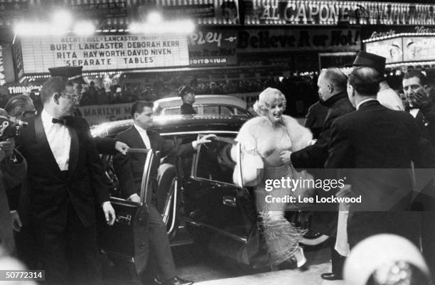 Actress Marilyn Monroe emerging from limo upon arrival at premiere of her new film Some Like It Hot in Times Square.