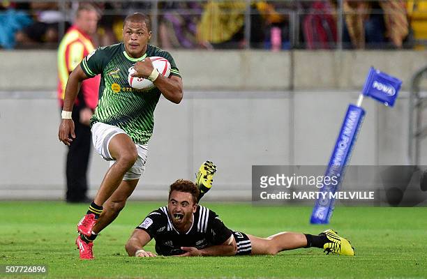 South Africa's Cheslin Kolbe runs out of a tackle by New Zealand's Joe Webber during the cup final on the second day of the Wellington Sevens rugby...
