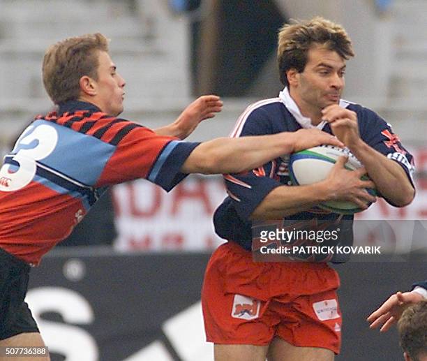 Le trois-quarts aile Christophe Dominici tente d'échapper au placage du trois-quarts centre écossais Jon Stuart, le 21 novembre 1999 au stade Jean...